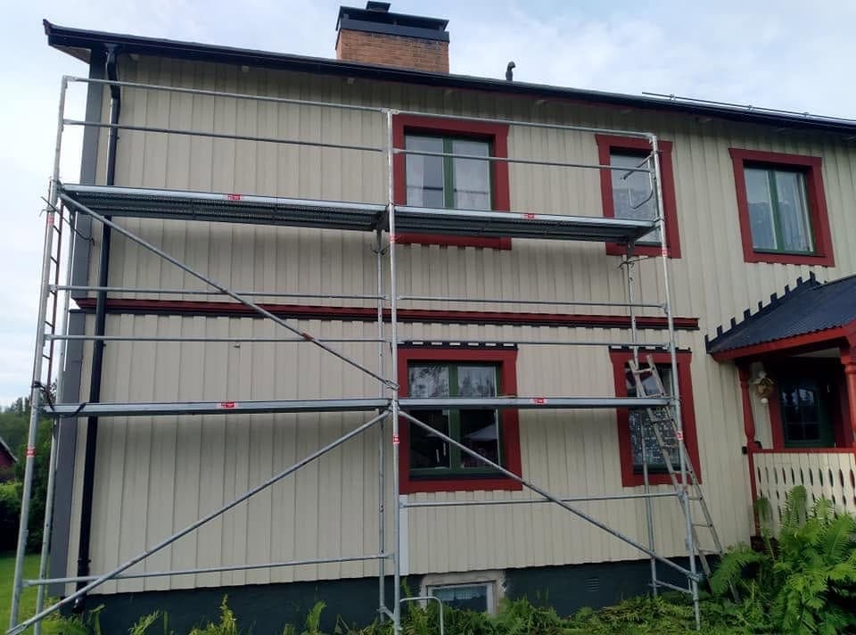 Fasadmålning med byggnadsställning på ett jämtländskt hus